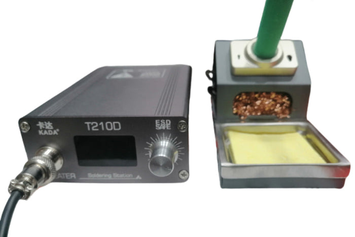 Kada T210D Thermostatic Soldering Station – 75W, Adjustable Temperature 120–450°c, LED Display, Auto Sleep, Pid Control - with a black control unit featuring a display and knob, next to a stand with a brass tip cleaner and yellow sponge.